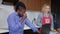 Tired overburdened African American man rubbing eyes messaging online on laptop as Caucasian woman cooking healthful