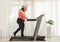 Tired overweight woman exercising on a treadmill at home