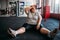 Tired overweight woman sits on the floor in gym