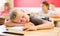 Tired preteen schoolboy sleeping at desk in classroom