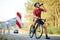 Tired road cyclist refreshing with water after ride