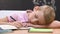 Tired schoolboy sleeping on desk at lesson, exhausted education, overwork