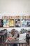 Tired schoolboy sleeping on stack of book sitting in classroom