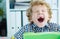 Tired schoolboy yawn sitting at the table in class at the lesson.