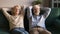 Tired senior spouses relax on cozy couch at home