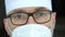 Tired serious mature male professional doctor in mask, eyeglasses and protective suite after taking a large number of