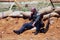 A tired soldier-reenactor rests on the sand.