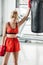Tired sportswoman in boxing gloves standing