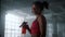 Tired sportswoman with water bottle standing in gym. Woman taking break