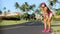 Tired sweating Running woman resting on road exercising wearing smart phone