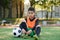 Tired teen soccer player on outdoors artificial sports stadium and tying the shoelace on his training boots.