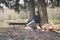 Tired traveller young guy on a halt forest lake camp