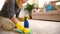 Tired wife cleans carpet and her husband lying on the sofa with newspaper.