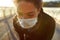 Tired woman. Close up photo of exhausted african female jogger in medical mask resting after run while standing on the