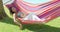Tired woman with grin laying in hammock