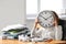 Tired woman hiding face behind clock at table in office. Time management concept