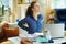 Tired woman in modern house in sunny day having back pain