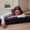 Tired woman pianist lies on musical instrument in home kitchen