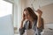 Tired woman sitting at desk with laptop, holding head, resting on hand, sleeping at workplace, bored young female