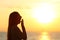 Tired woman yawning at sunset on the beach