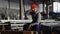 Tired worker in a helmet at a large metalworking plant. Shiftman in the finished product warehouse