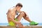 Tired workout man sitting by the sea with bottle of water