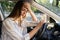 Tired young woman car driver suffer from headache or migraine pain inside vehicle touch forehead