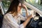 Tired young woman car driver suffer from headache or migraine pain inside vehicle touch forehead