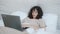 Tired young woman freelancer using laptop computer in bed then sleeping resting after work