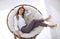 Tired young woman relaxes in a soft round chair