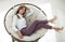 Tired young woman resting in a soft round chair