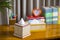 A tissue box on a wooden reading table.