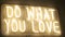 Title do what you love made of yellow neon light on wall. festive decoration