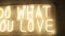 Title do what you love made of yellow neon light on wall. festive decoration