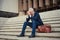 To be successful in business, you need to persevere. Shot of a dejected businessman sitting on the stairs outside his