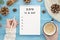 To do list 2019. Woman hand holds coffee and gold pen on rustic blue wooden planks with anise star, pine cones.