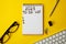 To do list 2023. Notepad and mobile phone on a yellow background.