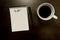 To do list on gridded spiral notepad with pen and cup of coffee - on dark timber