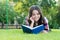 To succeed you must read. Happy kid read book lying on green grass. School library. Literacy education. Home reading