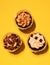 To view on three delicious, chocolate, sweet cupcakes on yellow background