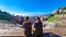 Toarmina - Tourist couple with panoramic view on snow capped Mount Etna volcano seen from ancient Greek theatre of Taormina, Italy