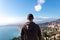 Toarmina - Tourist man with panoramic view on snow capped Mount Etna and the Mediterranean sea from Taormina, Sicily, Italy