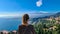 Toarmina - Tourist woman with panoramic view on snow capped Mount Etna and the Mediterranean sea from Taormina, Sicily, Italy