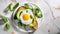 toast with avocado, fried egg and spinach leaves on a plate on a marble background with copy space. Nutritious healthy