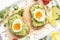 Toast with avocado puree and soft-boiled egg on white tray, liquid yolk, delicious breakfast, light sandwich. Healthy food