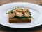 Toast with baby spinach and shrimps on plate