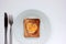 Toast bread with fried egg in a heart shaped hole on plate on white background. Creative Valentine\\\'s day