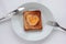 Toast bread with fried egg in a heart shaped hole on plate on white background. Creative Valentine\\\'s day