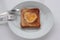 Toast bread with fried egg in a heart shaped hole on plate on white background. Creative Valentine\\\'s day