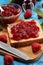 Toast bread with homemade raspberry jam or marmalade on table served with butter for breakfast or brunch